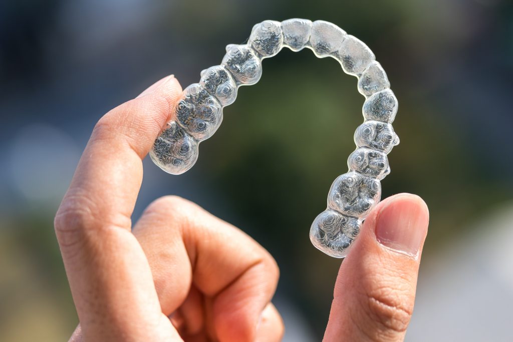 person holding invisalign aligner