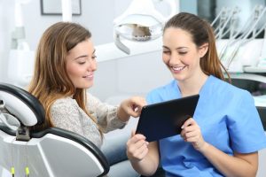 Young female patient discussing treatment with a female dentist